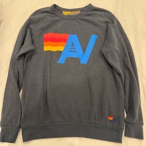 Aviator Nation Charcoal Crewneck with Blue Logo and Red-Orange-Yellow Flag